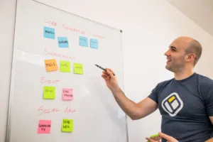 smiling man standing by whiteboard