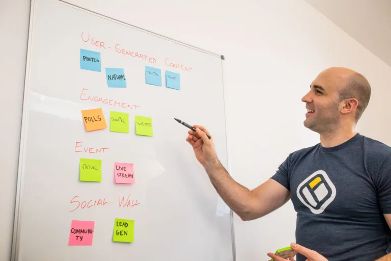 smiling man standing by whiteboard