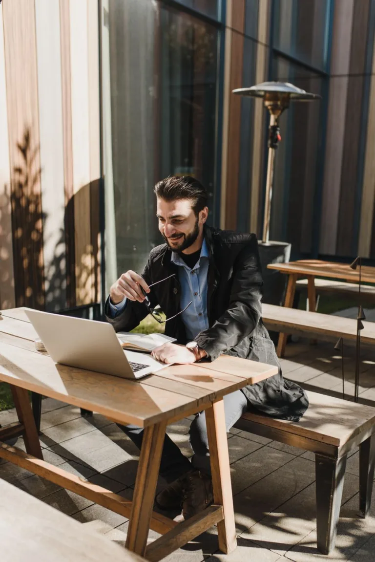man in black jacket sitting on wooden bench